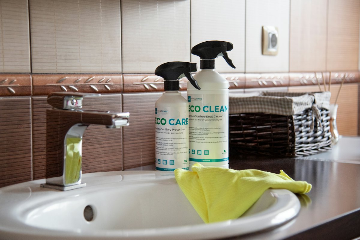 Freshly cleaned bathroom sink with cleaning supplies