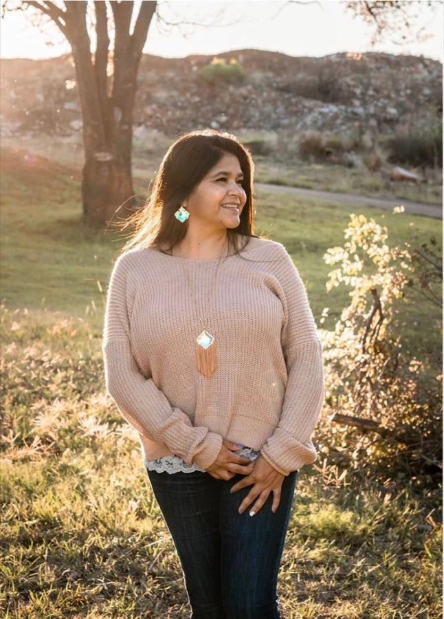 Idalia S., owner of Segovia Cleaning Services, smiling outdoors at golden hour